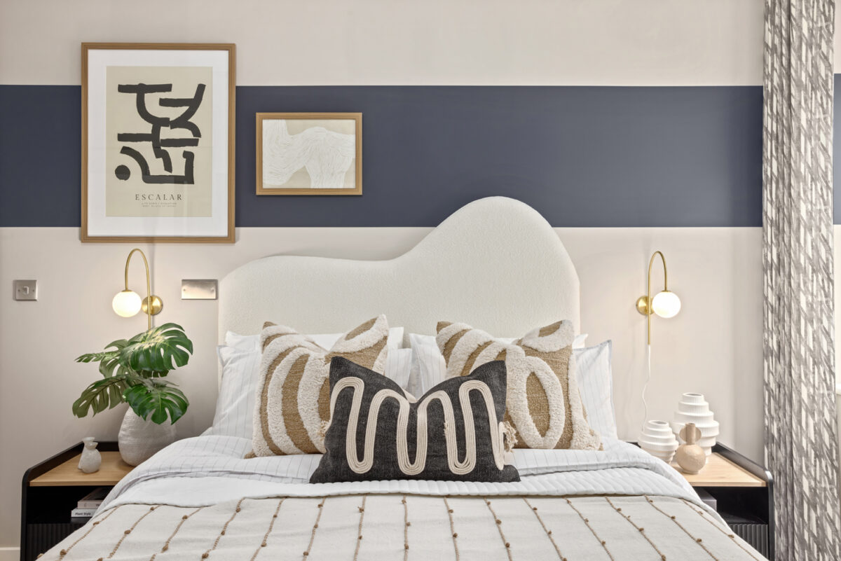 Bedroom with bed, white headboard and bedding, cushions and night stands on each side