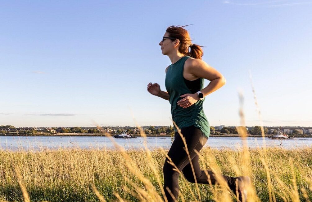 Woman running along riverside walkway in Barking